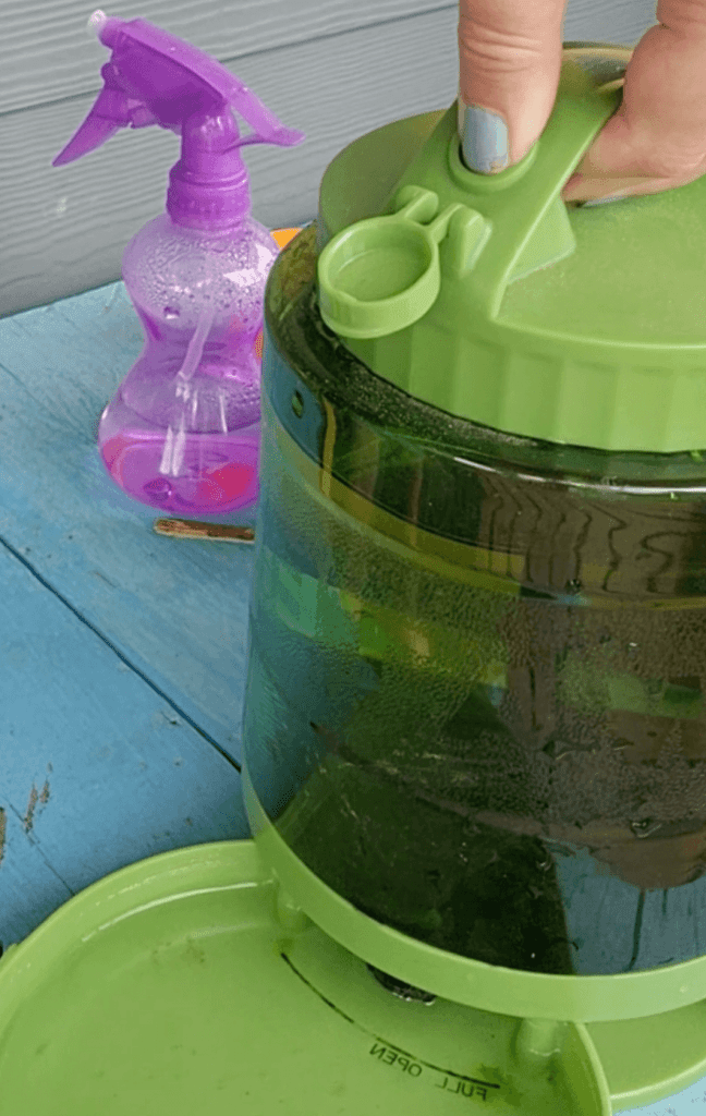 A close up of a hand operating the lid of the water dispenser