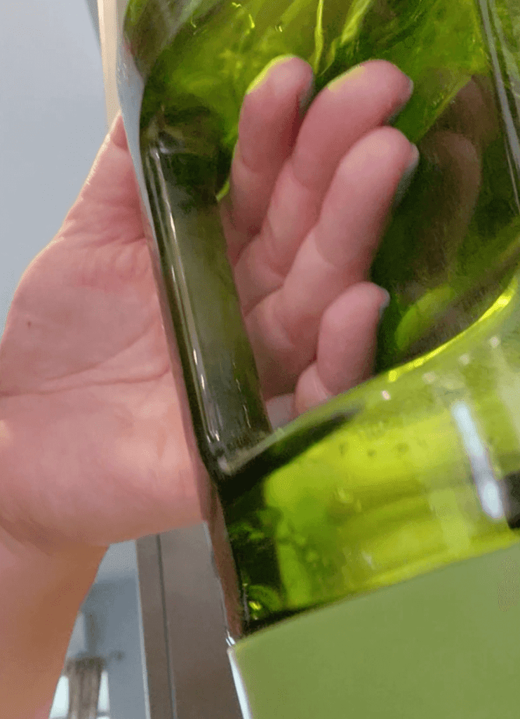 A close up of a hand holding the handle of the dispenser