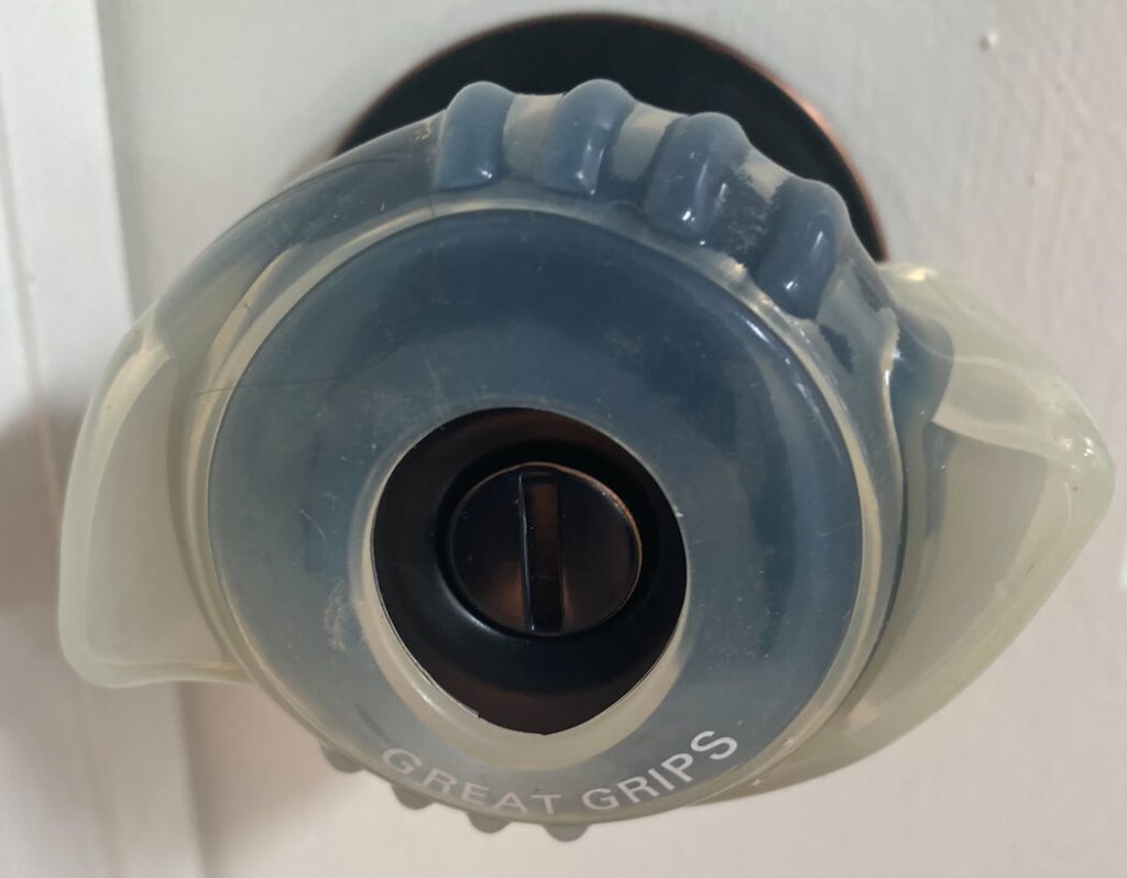 Clear plastic door knob grip with small "wings" on either side and texture for extra grip.