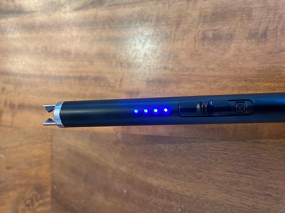 Close up of switched move forward, prongs extended, blue lights activated and small black power button exposed.