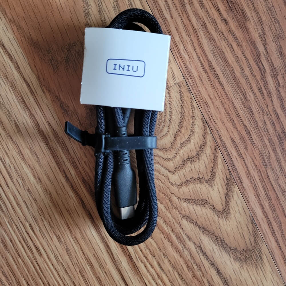 A folded charging cable with a card label on reading INIU