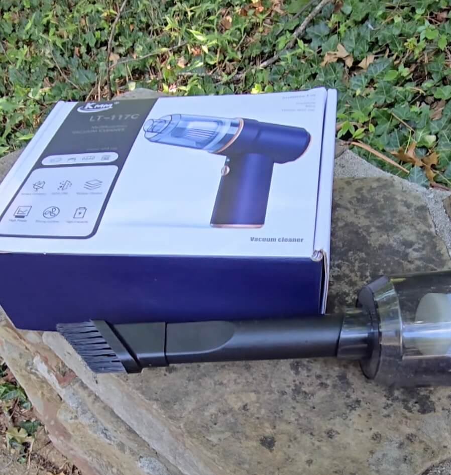 A close up of the extension piece, which is black and slender and has a brush on the tip of the opening.