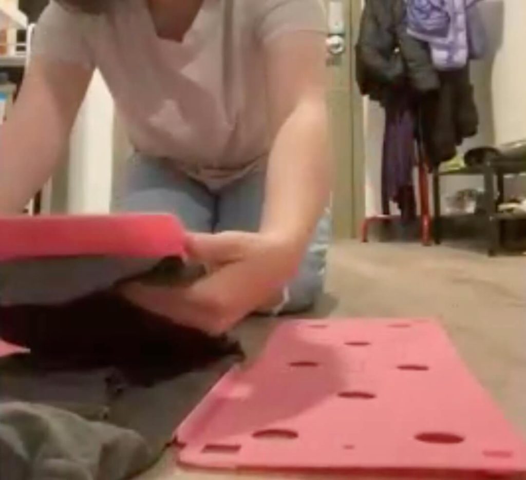 Final step, folding the bottom part of the tool up toward the top part, finishing the fold of the shirt.