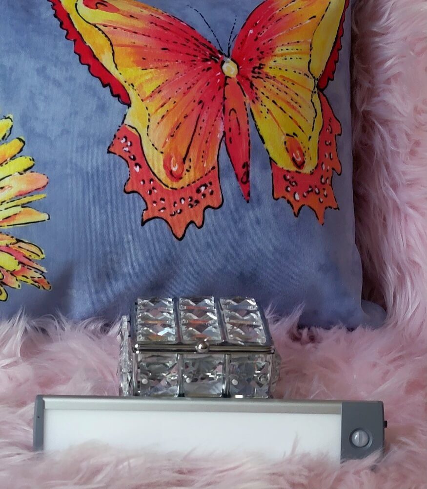 Light strip off, displayed on a fuzzy blanket. The motion sensor is visible on the right side of the device.