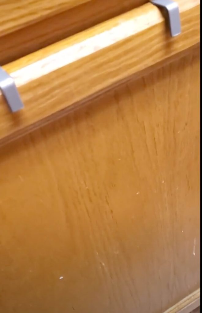 Silver hooks are visible over the top of the cabinet door (looking at the closed cabinet door)