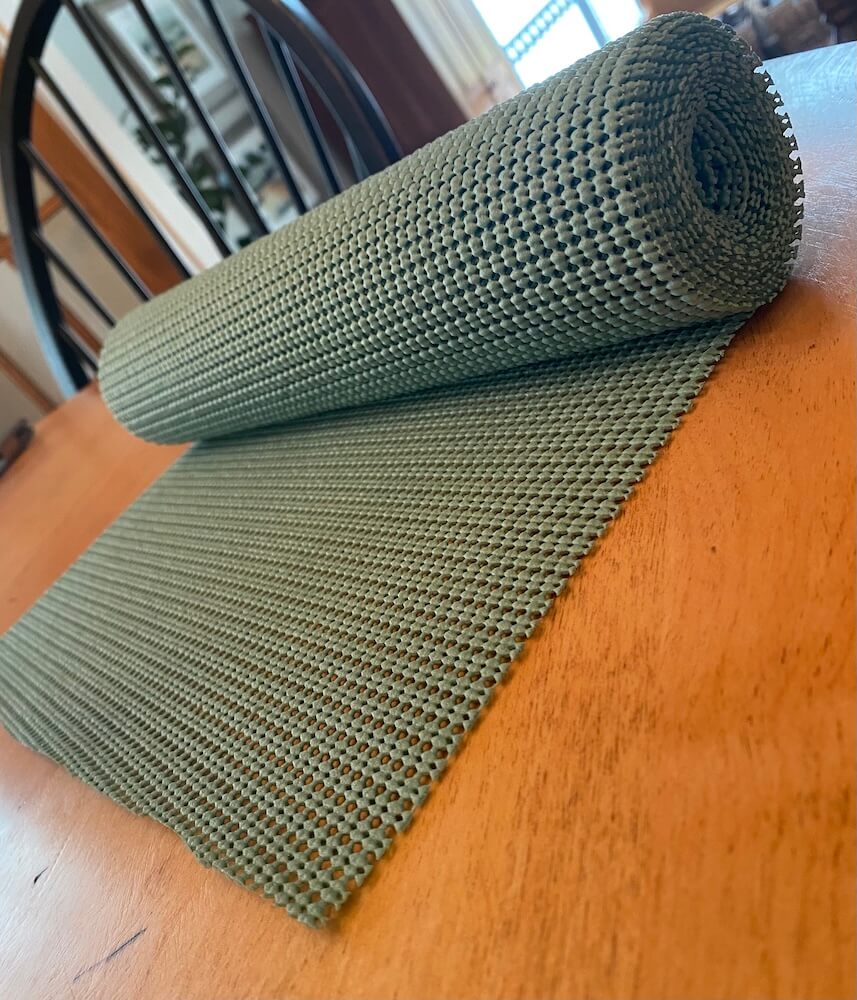 Image of partially unraveled teal shelf liner on a wooden table