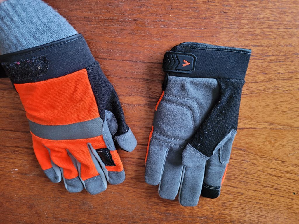 VGO leather gloves on a table. The top is bright orange and gray the palm side is gray and black