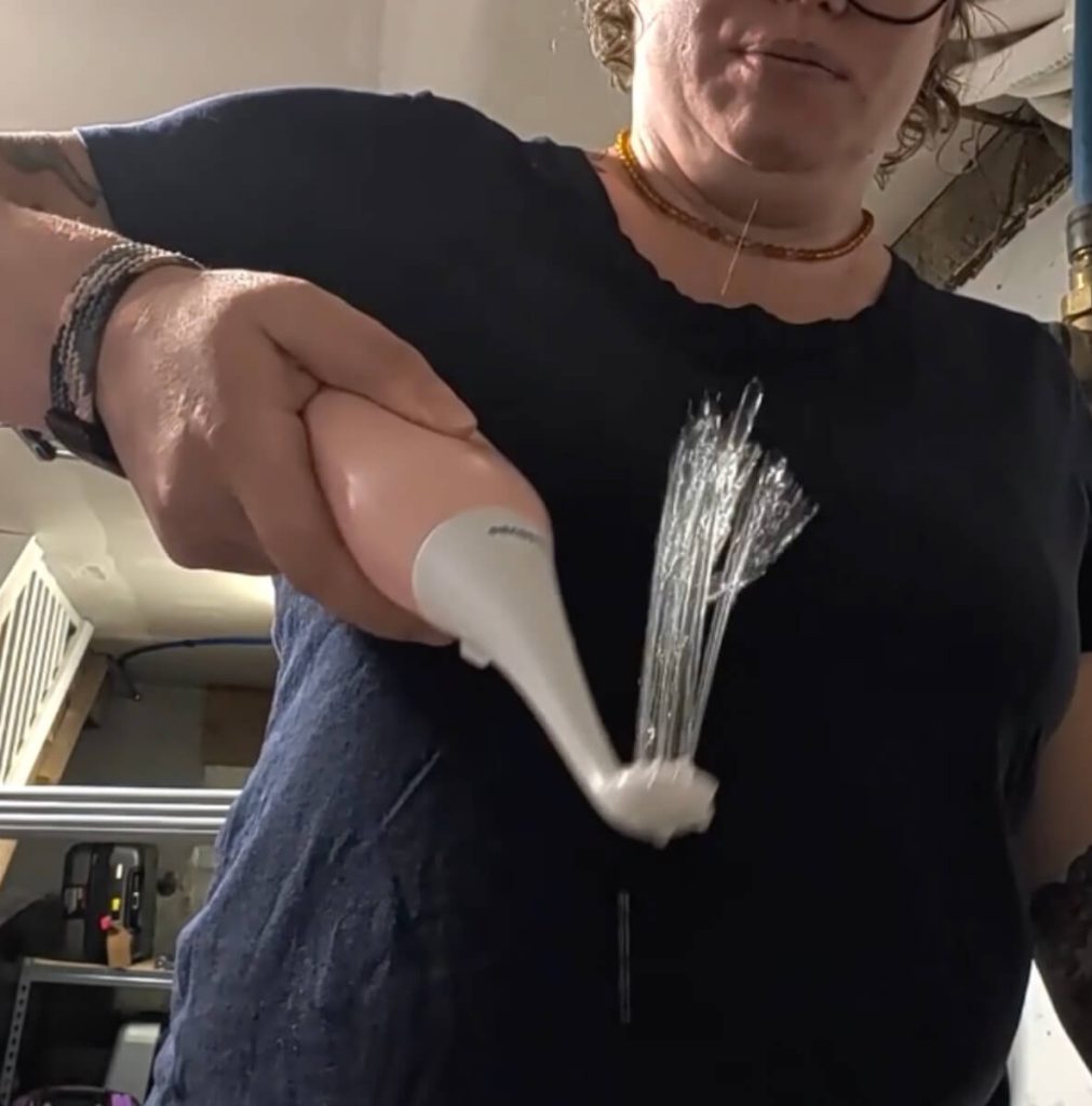 A person demonstrating a portable handheld bidet.